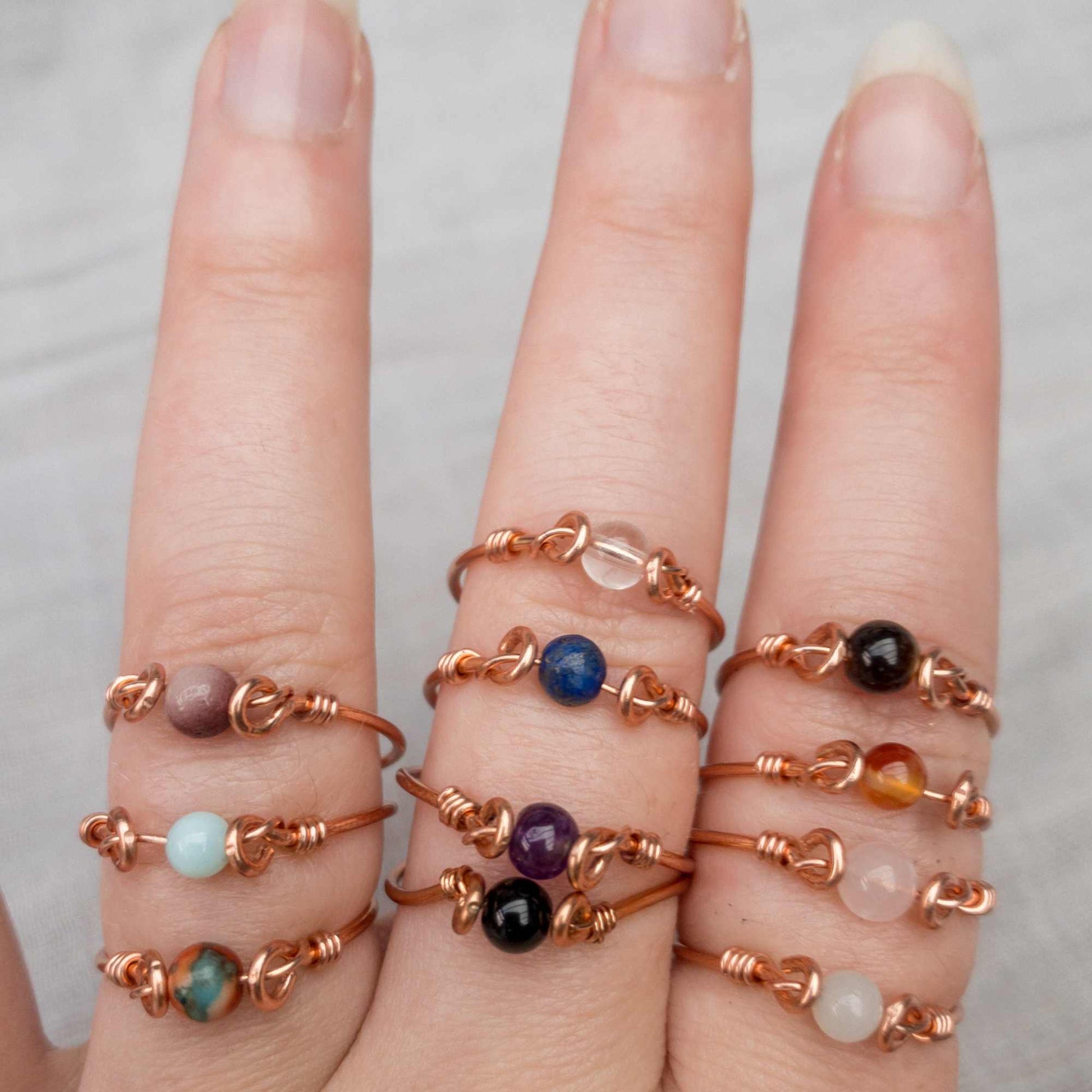 hand showing rings in different crystals